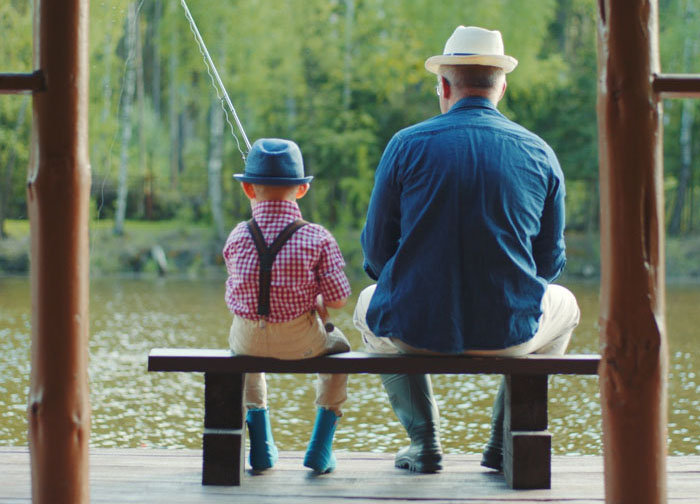 A grandpa and grandson are fishing together.